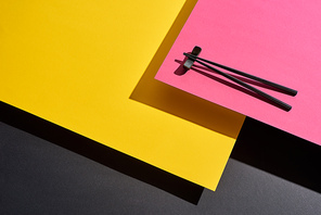 chopsticks on pink, yellow and black surface