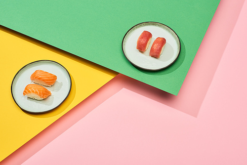fresh nigiri with salmon and tuna on yellow, pink, green background