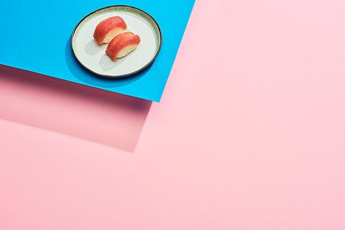 fresh nigiri with tuna on blue, pink background