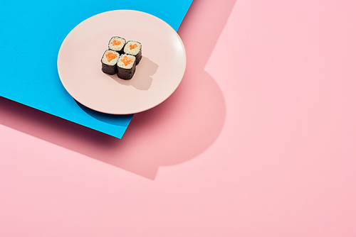 fresh maki with salmon on blue, pink background