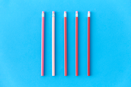 drawing, education and object concept - five lead pencils with eraser on tip on blue background