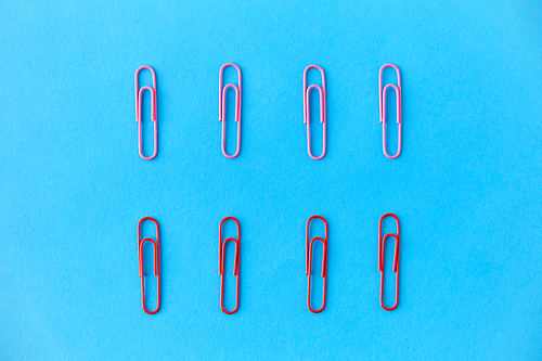 office supplies, stationery and object concept - clips on blue background