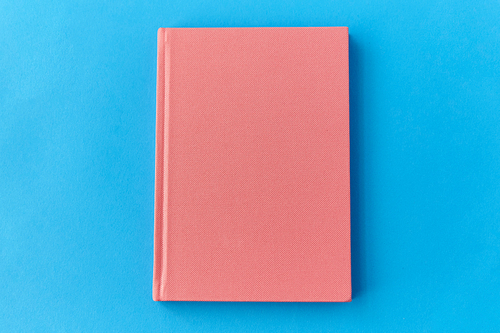 education and object concept - notebook or diary on blue background