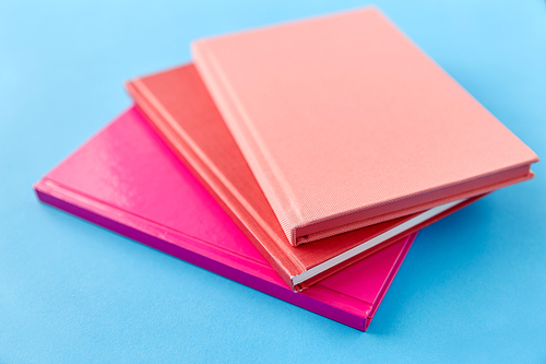 education and object concept - notebooks or books on blue background