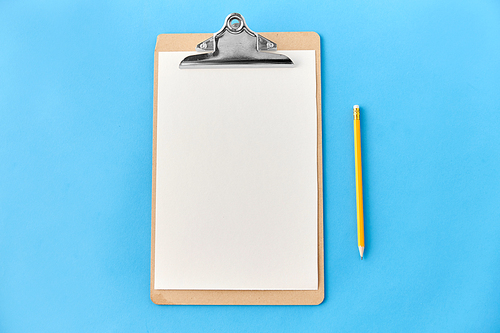 drawing, education and object concept - clipboard with white paper sheet and pencil on blue background