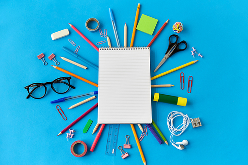 education, office and object concept - notebook and stationery or school supplies on blue background