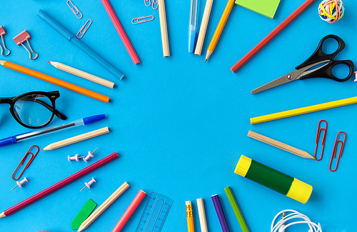 education, office and object concept - frame of stationery or school supplies on blue background