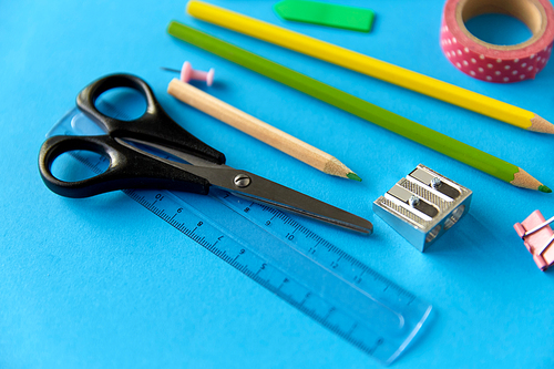 education, office and object concept - close up of stationery or school supplies on blue background