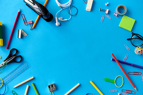 education, office and object concept - frame of stationery or school supplies on blue background