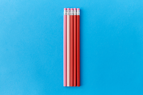 drawing, education and object concept - five lead pencils with eraser on tip on blue background