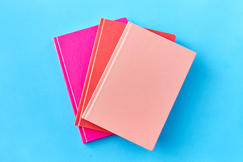 education and object concept - notebooks or books on blue background