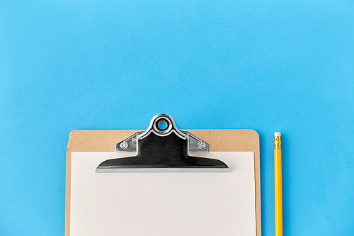 drawing, education and object concept - clipboard with white paper sheet and pencil on blue background