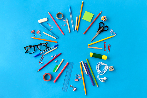 education, office and object concept - frame of stationery or school supplies on blue background