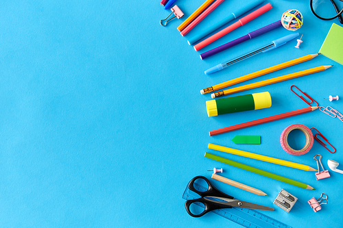 education, office and object concept - stationery or school supplies on blue background