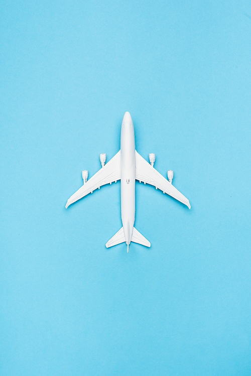 top view of white plane model on blue background