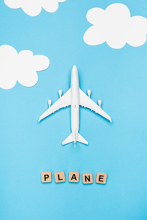 top view of airplane model and cubes with word plane on blue sky background