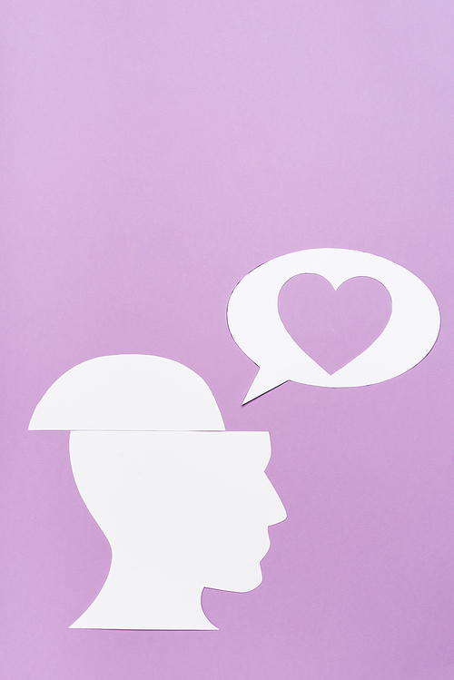 top view of paper human head and speech bubble with heart on violet background