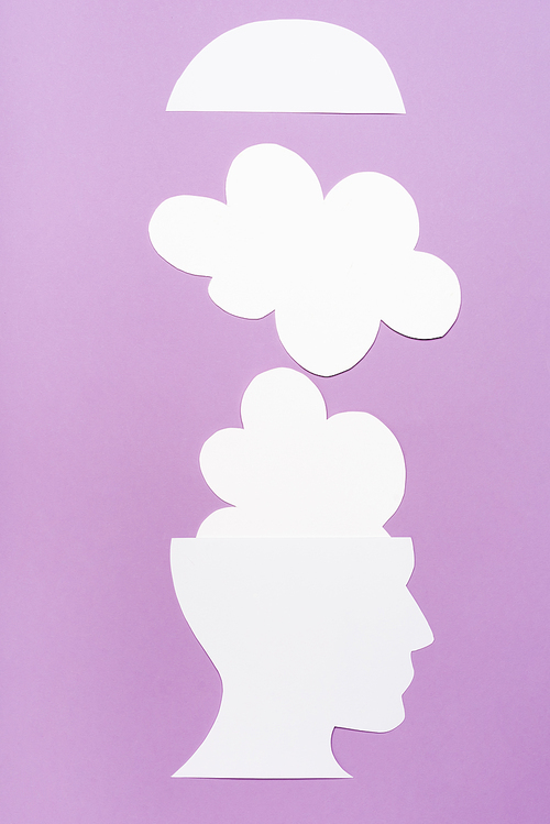 top view of paper human head and clouds on violet background