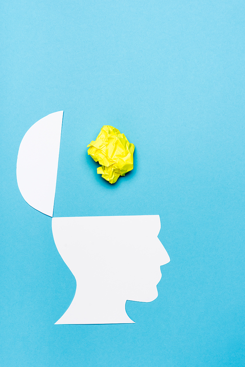 top view of paper human head and crumpled paper on blue background