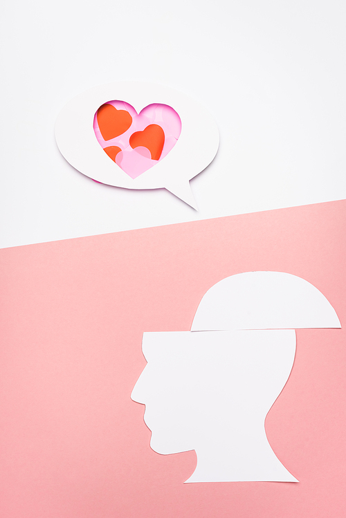 top view of speech bubble with hearts and human head on white and pink background