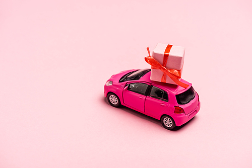 toy car and gift box on pink background