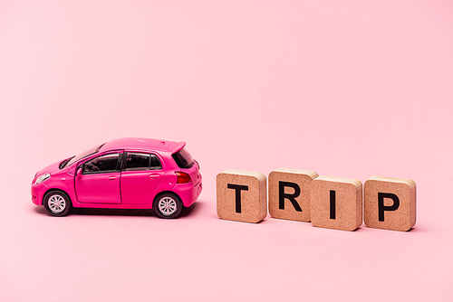 car and word trip on cubes on pink background