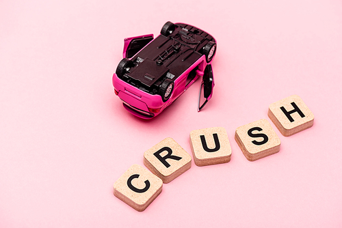 toy car and word crush on cubes on pink background