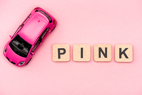 top view of toy car and word pink on cubes