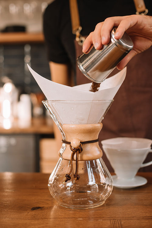 partial view of barista preparing filtered coffee using chemex