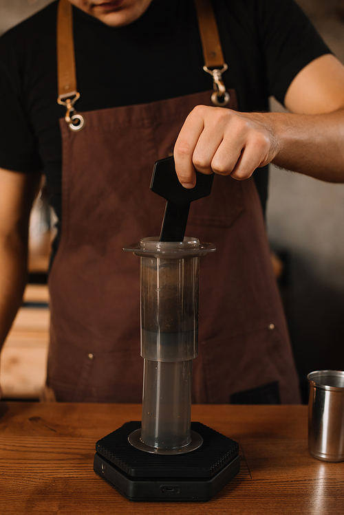 cropped view of barista preparing coffee with aeropress