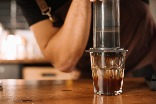 partial view of barista preparing coffee with aeropress