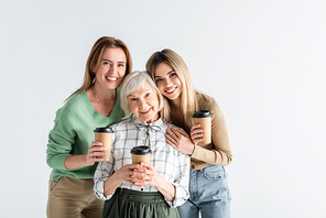 three generation of happy women holding paper cups isolated on white