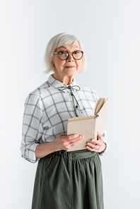senior woman in glasses holding book isolated on white