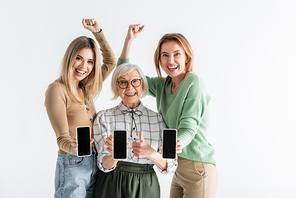 three generation of excited women holding smartphones with blank screen isolated on white