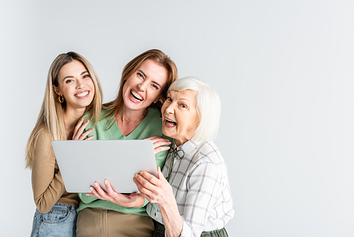 three generation of joyful women  near laptop isolated on white