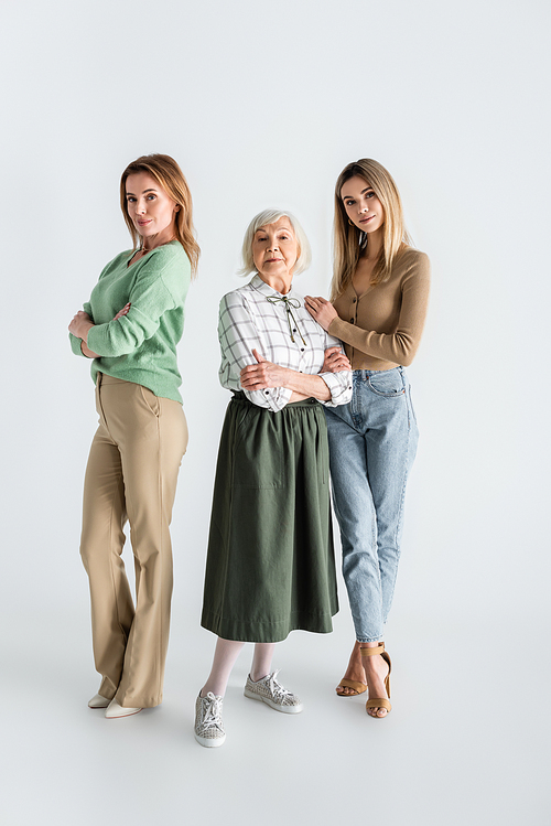 full length of three generation of women  and posing on white