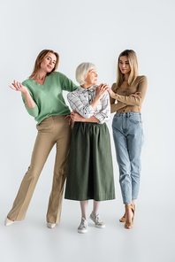 full length of three generation of women posing on white