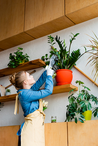 young beautiful woman in gloves looking at plants