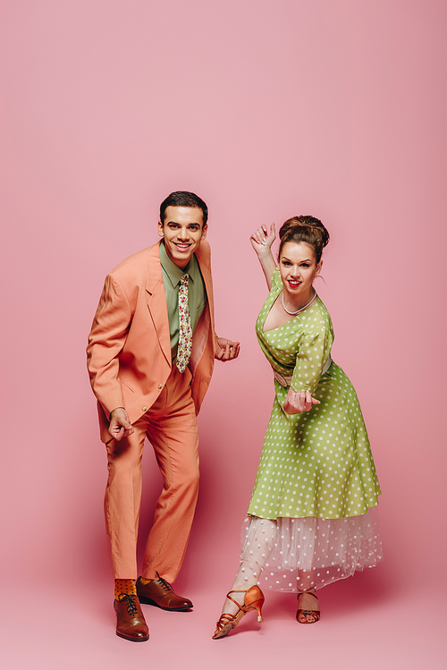 young dancers  while dancing boogie-woogie on pink background