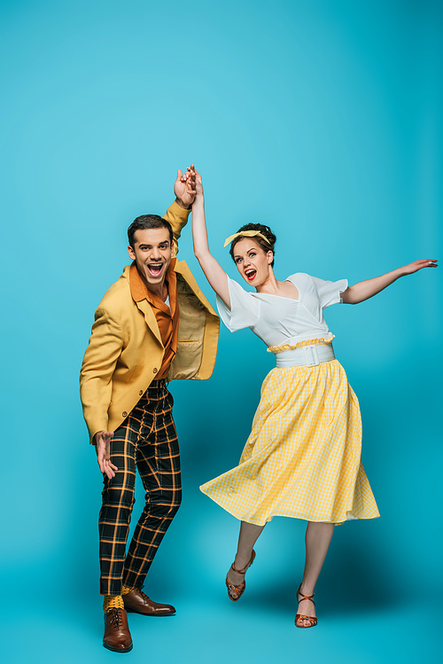 happy dancers holding hands while dancing boogie-woogie on blue background