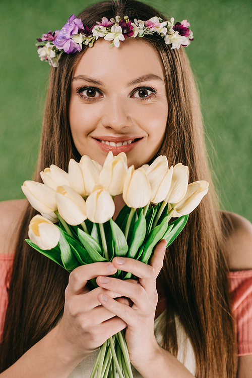 smiling beautiful and brunette woman in wreath holding tulips and 