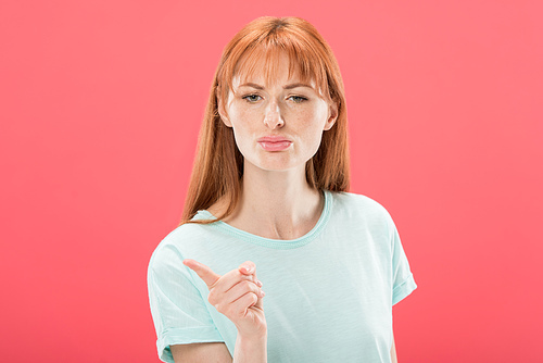 front view of displeased redhead girl in t-shirt  and shaking finger isolated on pink