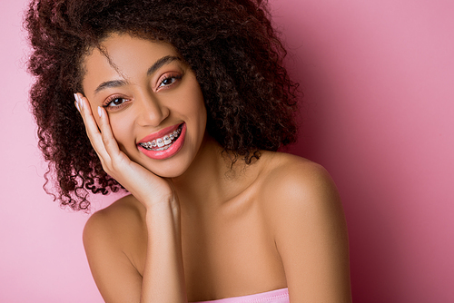 beautiful happy african american girl with dental braces on pink