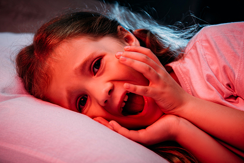 frightened child screaming and  while lying in dark bedroom