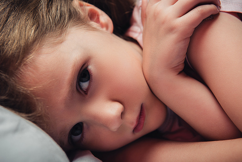 cute, frightened child  while lying in dark bedroom