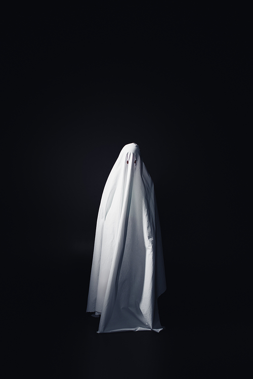 horrible ghost in white bedsheet isolated on black with copy space