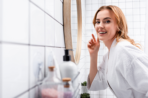 happy woman  near bottles on blurred foreground