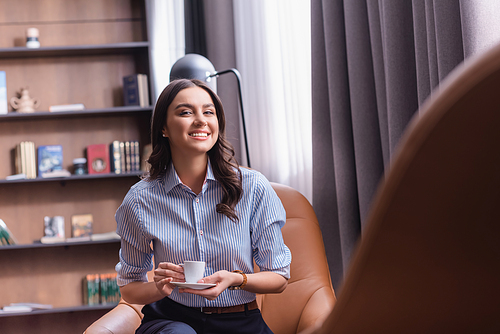 successful businesswoman  while sitting in lounge zone with cup of coffee