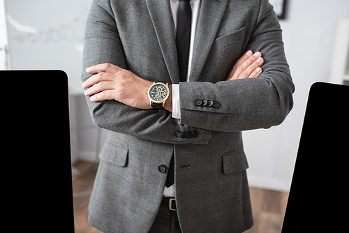 cropped view of trader in formal wear and wristwatch standing with crossed arms