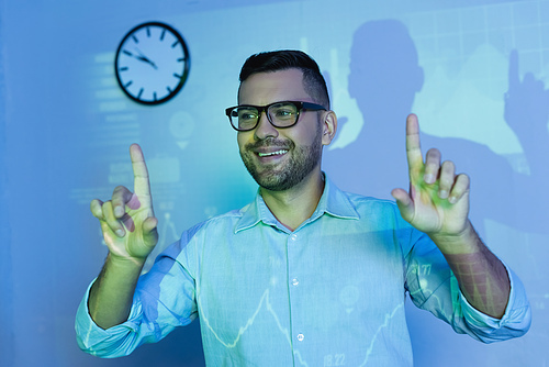 happy businessman in glasses pointing with fingers in office